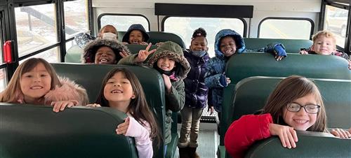 Group of smiling students on a bus.